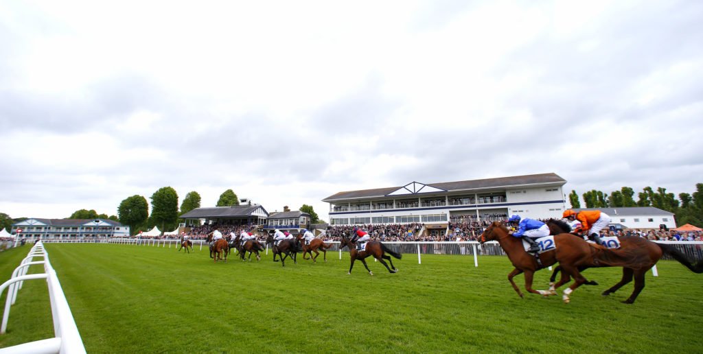 Runners in The Sky Bet Handicap Stakes passing The Bank Holiday crowd in the stands