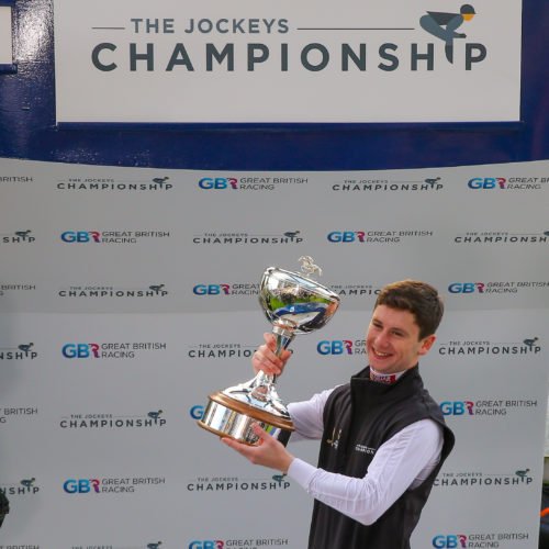 Oisin Murphy holding the 2019 Champion Flat Jockey trophy.