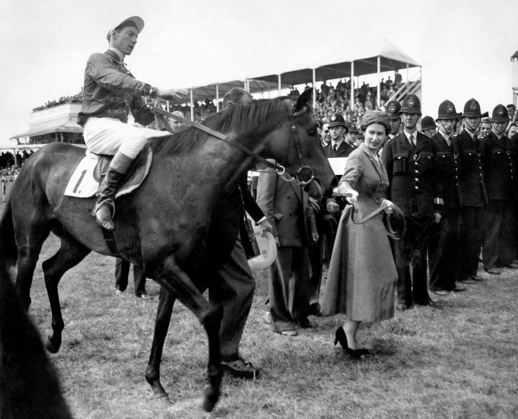 The Queen leads in her Oaks winner, Carrozza, with Lester Piggott in the saddle.