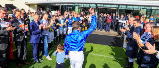 William Buick walks out with his son Thomas to the applause of the crowd before being crowned The Champion Jockey