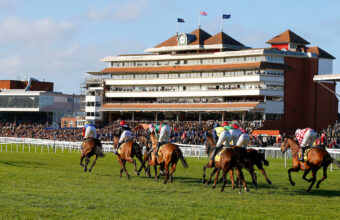 Runners passing the stands at Newbury