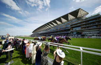 Illinos and Ryan Moore on his way to winning The Queen’s Vase at Royal Ascot with the grandstand behind